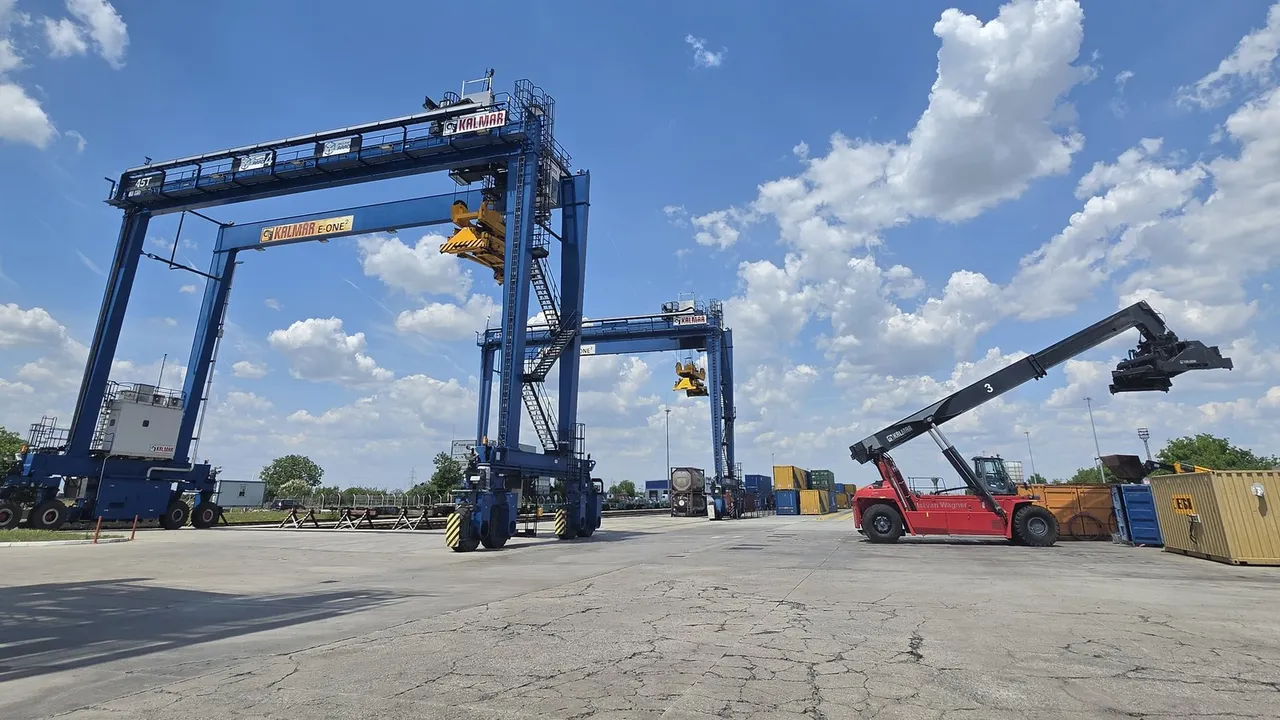 Zwei blaue Portalkrane und ein roter Reachstacker auf der Umschlagfläche des Terminals Arad
