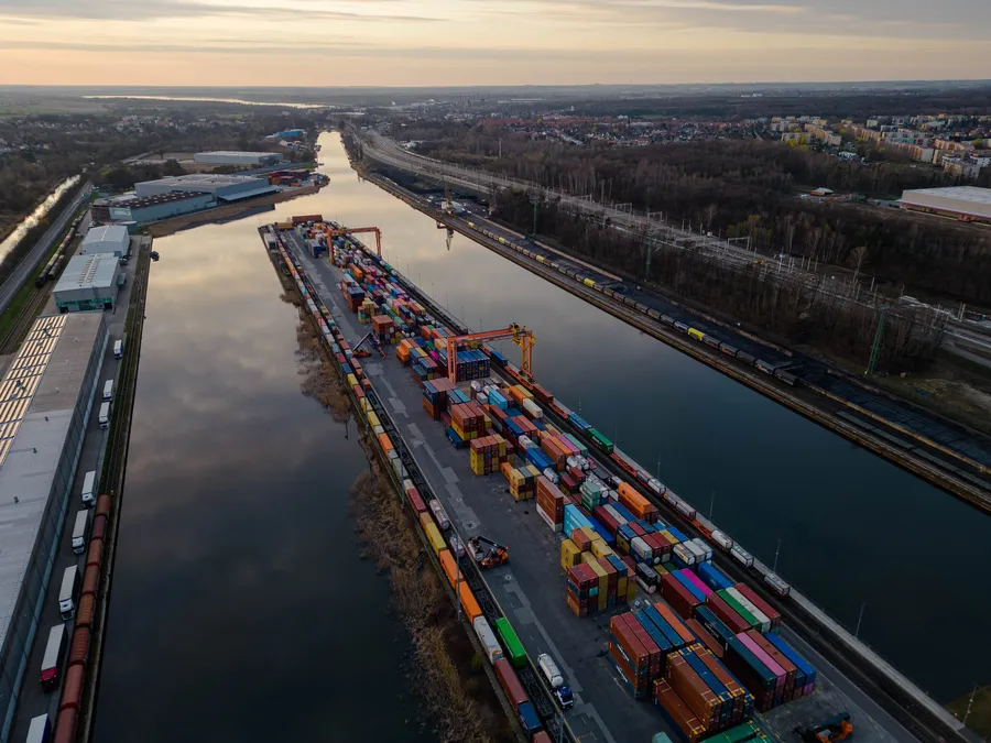 Binnenschiff mit Containern auf dem Weg zu einem trimodalen Terminal