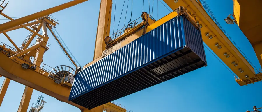 Portalkran hebt einen Container über dem Terminal