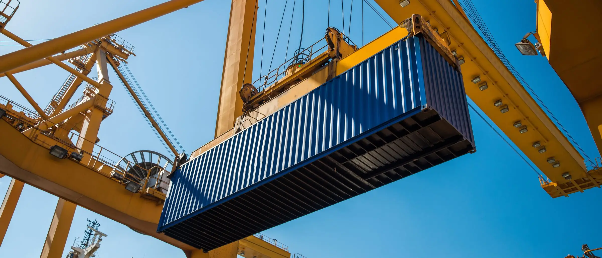 Portalkran hebt einen Container über dem Terminal